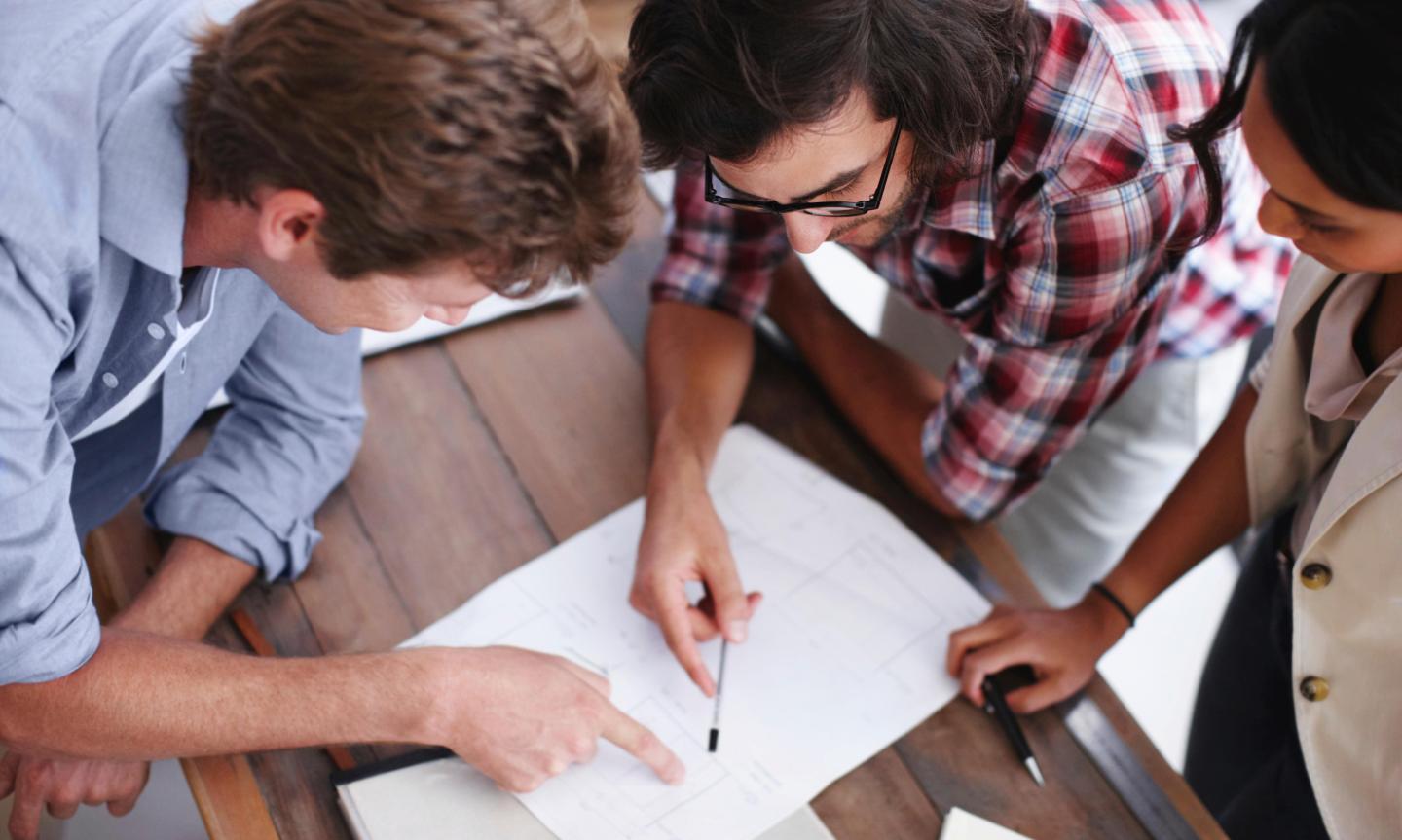 A group of people analysing paperwork on a table