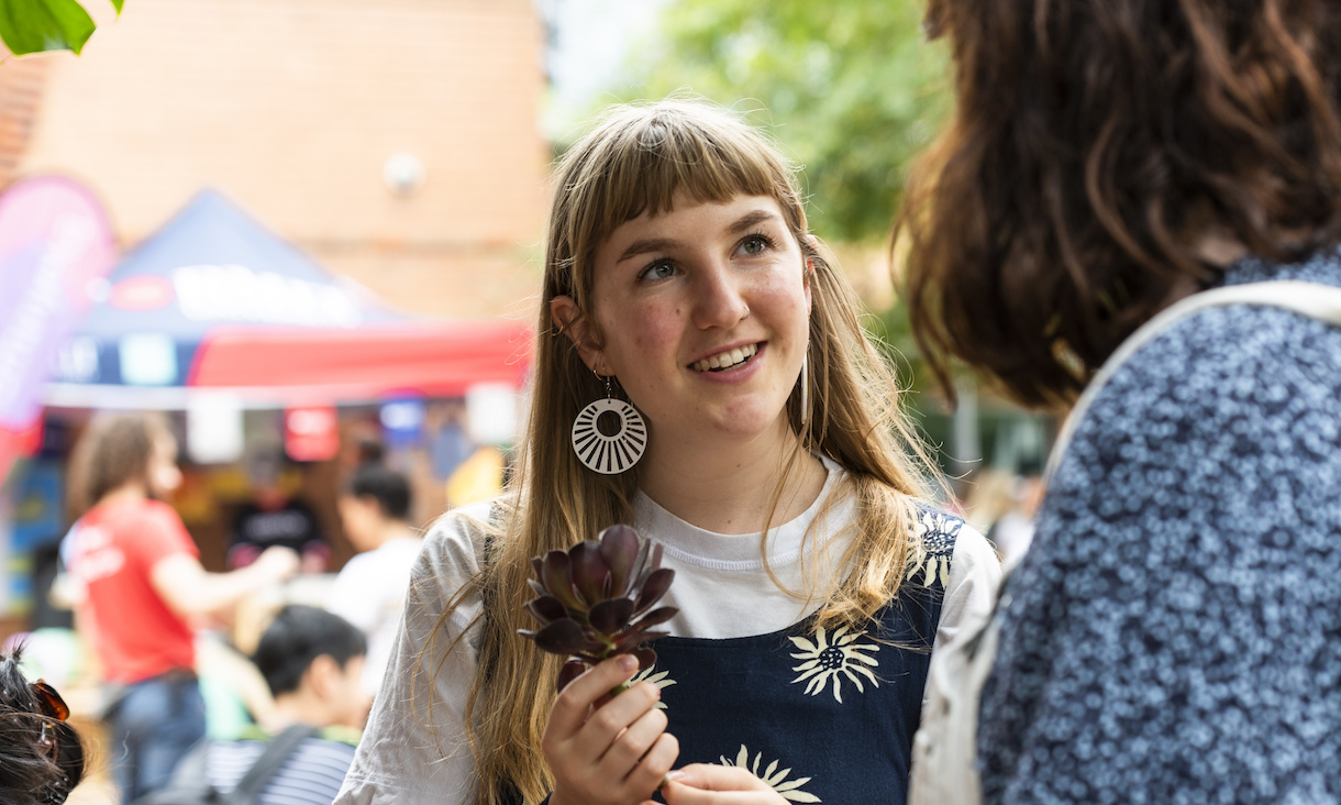 A student smiles as she speaks to someone off-camera.