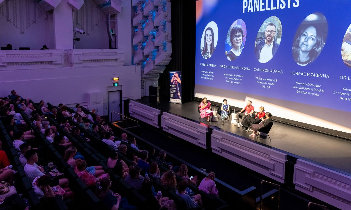 Panel on stage speaking to audience