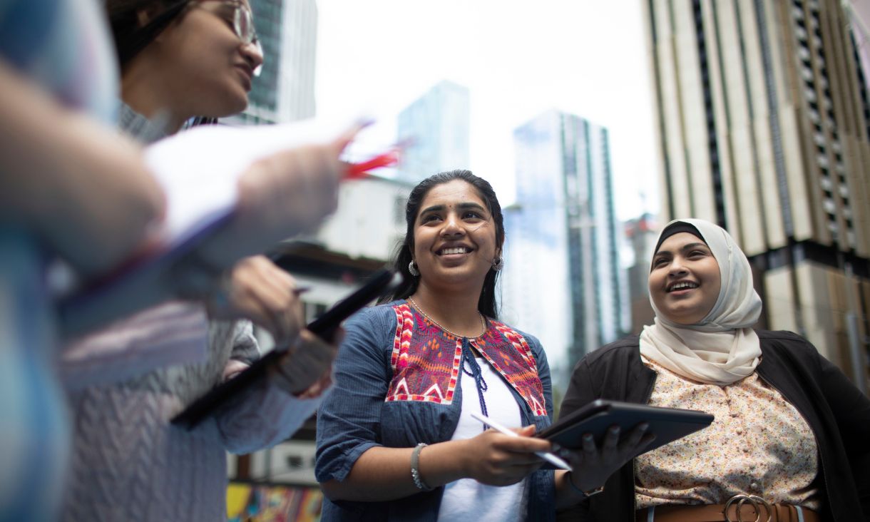 four women talking outside in the city 