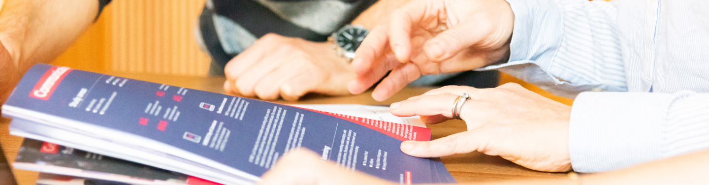 Close-up shot of hands pressing down pages of a RMIT brochure