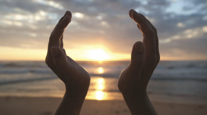 Image of hands around the sun.